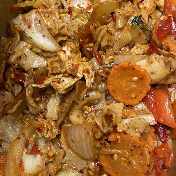Close-up of spicy Thai noodles with chicken, carrots, and red peppers from Spice I Am.